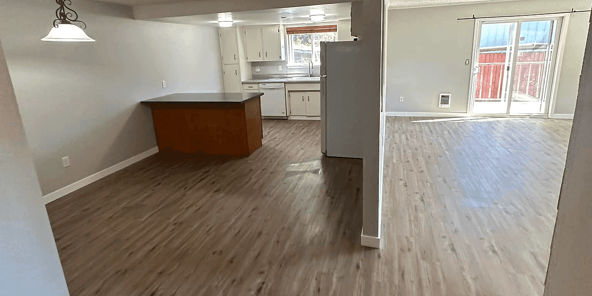 An open-plan finished interior with the kitchen visible beyond.