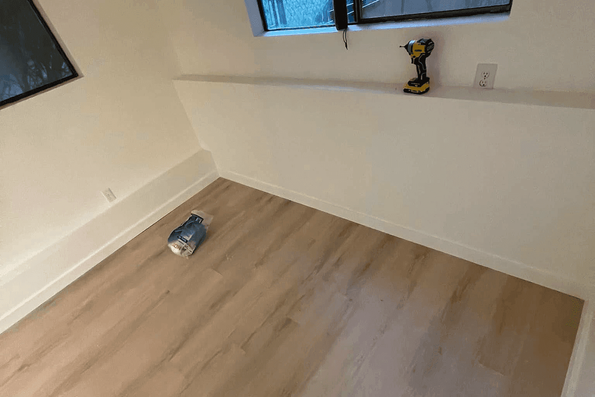 A finished room with new light wood flooring.